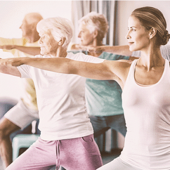 group of adults practicing yoga in a studio