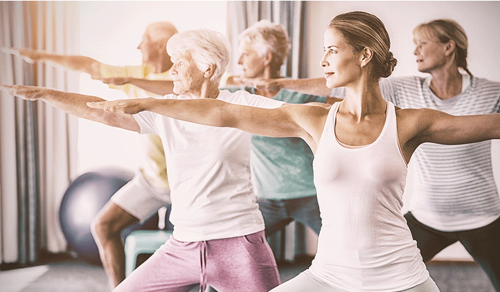 group of adults practicing yoga in a studio